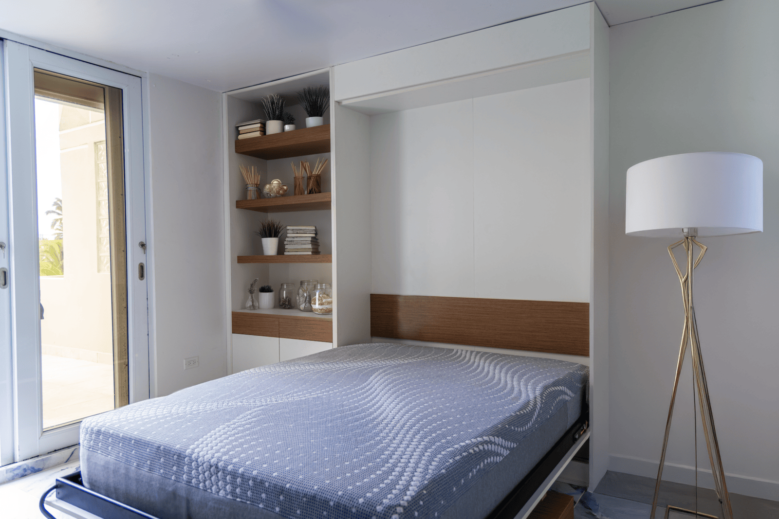 Custom PVC Murphy bed with walnut shelving in a coastal Puerto Rico condo